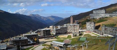 A hotel complex with multiple buildings, a central courtyard, and a mountainous backdrop.