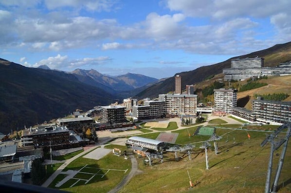 A hotel complex with multiple buildings, a central courtyard, and a mountainous backdrop.