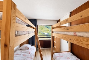 A bunk bed room with a view of a green landscape. - 10m from ski slopes, 4th floor, balcony, tv, ski locker, 31m², Les Menuires (Les Menuires)