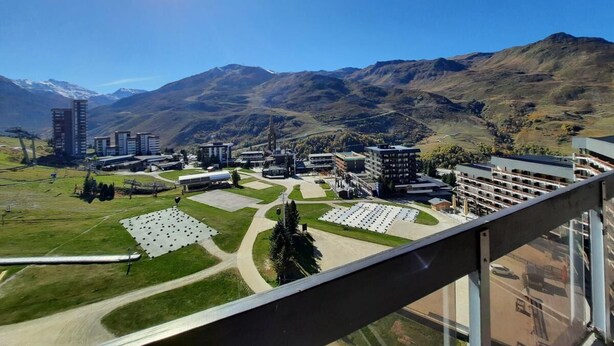 A view of a campus with buildings, parking lots, and mountains in the background. - 10m from ski slopes, 10th floor, balcony, tv, ski locker, 48m², Les Menuires (Les Menuires)