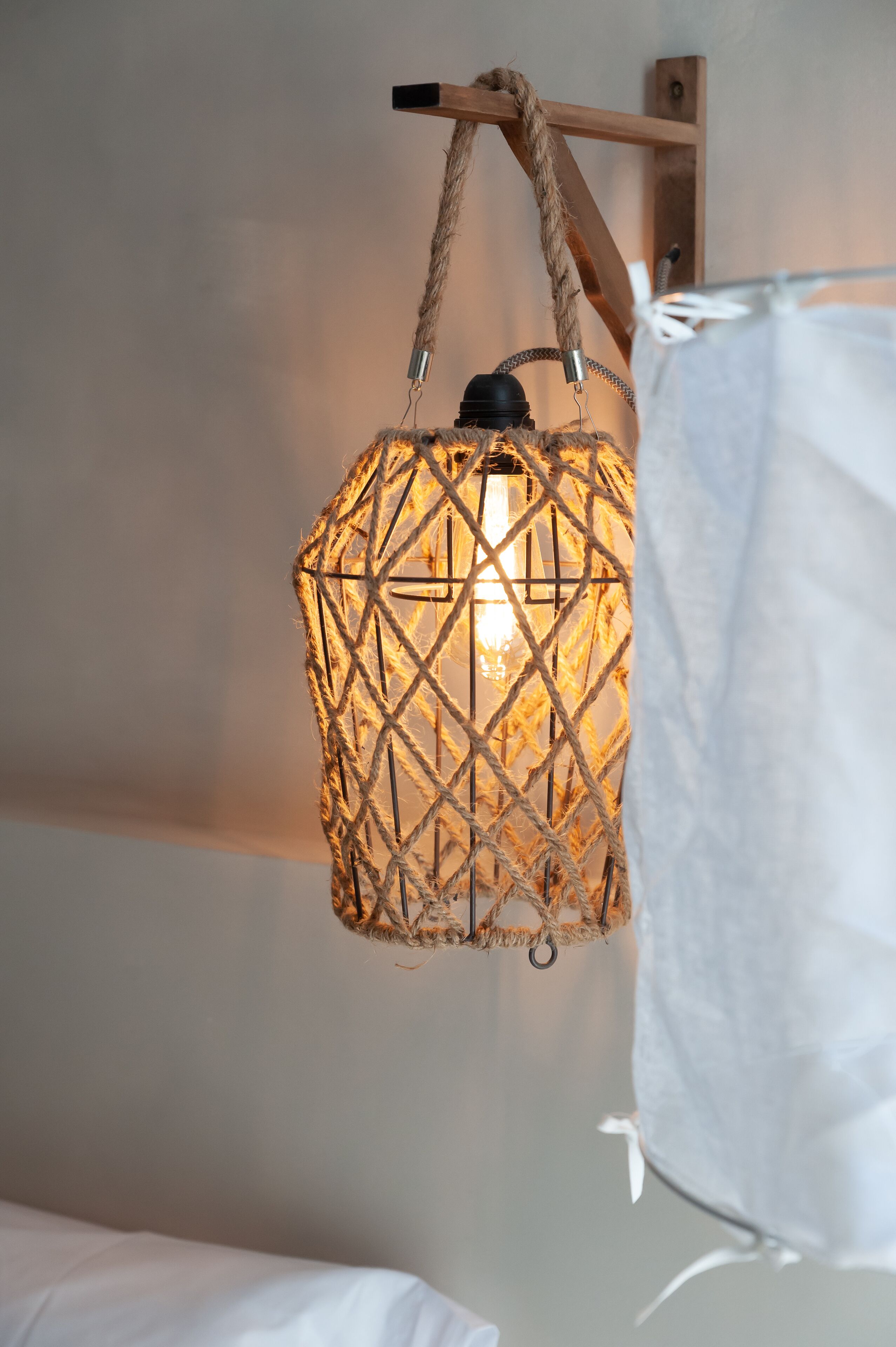 Una lampada a sospensione con un motivo geometrico e una lampadina a vista.