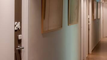 A hotel hallway with doors numbered 24, 25, and 26.