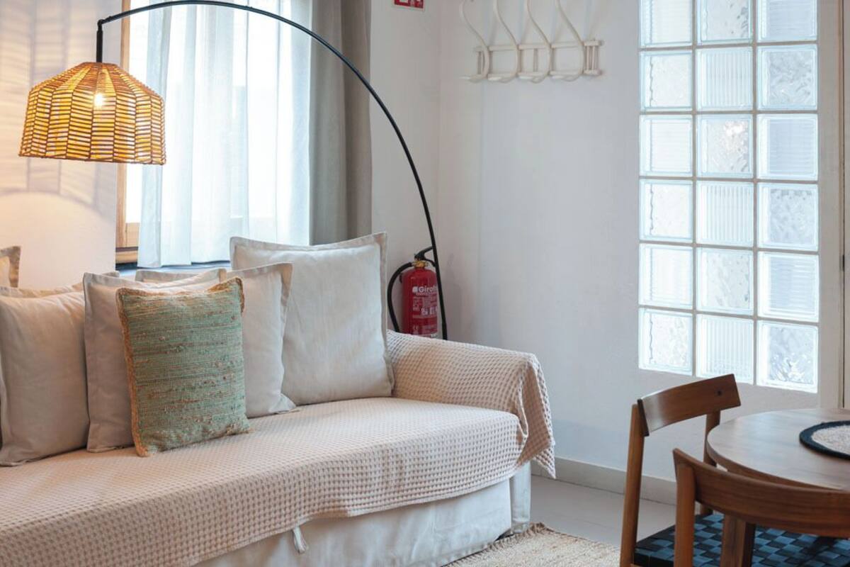 Una habitación acogedora con sofá, una mesa redonda de madera y un amplio ventanal con vistas.
