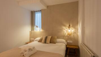Una habitación de hotel con una cama grande, una mesita de noche, una lámpara y un radiador.