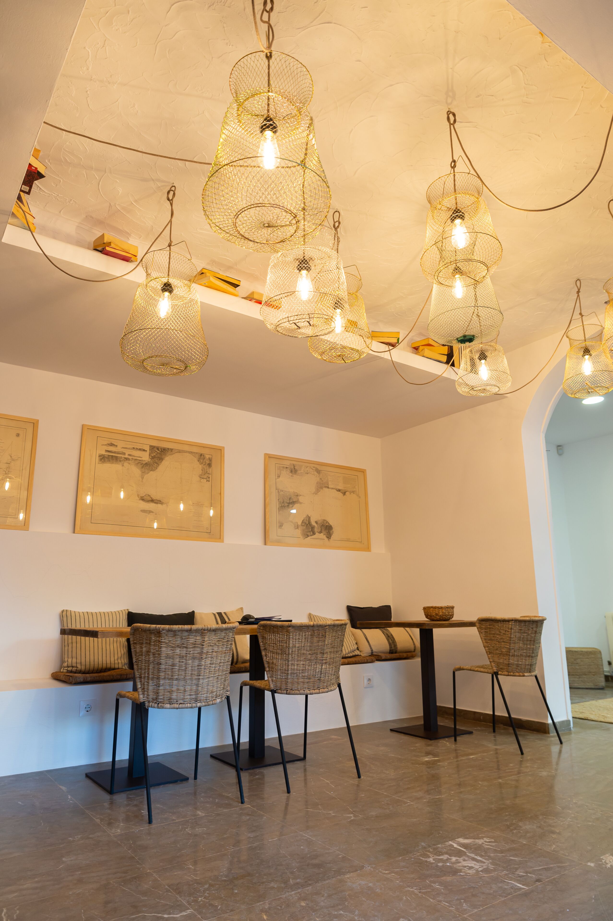 A dining area with wicker chairs, a table, and pendant lights.