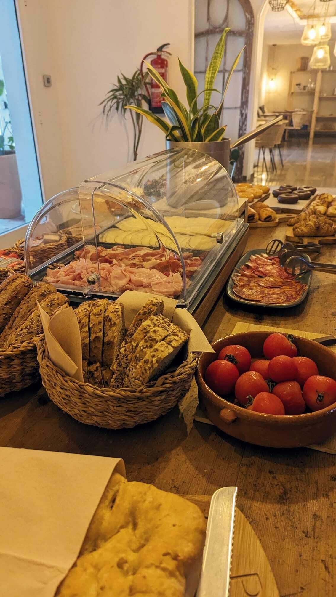 Un bufé con diversas opciones de comida, como carnes, quesos y panes.