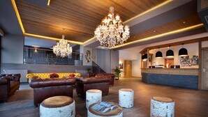 A lobby with leather sofas, birchwood stools, a reception desk, and chandeliers. - Wifi, 50m from resort center, fitness, swimming pool, sauna, hammam, balcony, tv, ski locker, 45m² (Les Arcs)