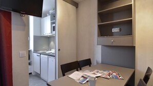 A compact kitchen with white appliances, a dining table with chairs, and a bookshelf. - Ski-in/ski-out & foot of the slopes, 2nd floor, balcony, tv, 28m², La Plagne (La Plagne)