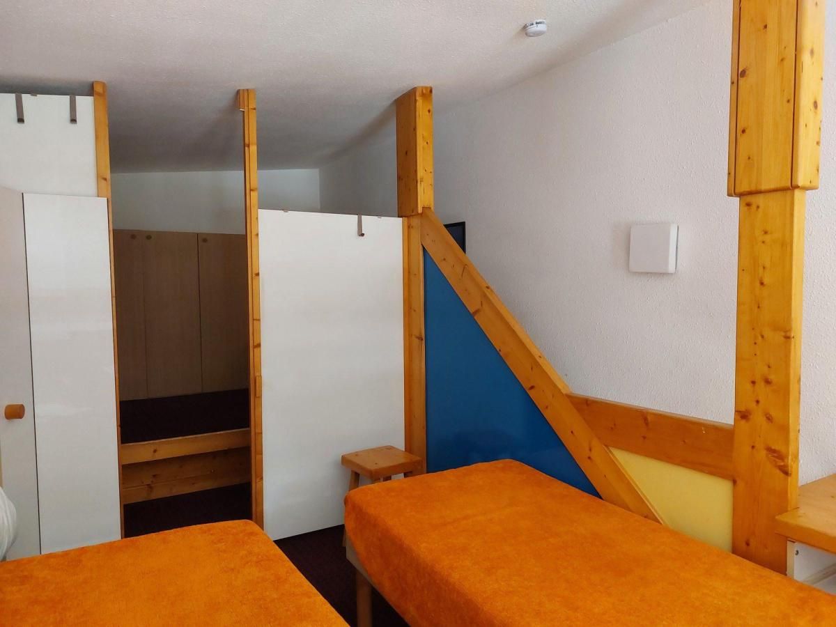A room with bunk beds, a wardrobe, and a small table.