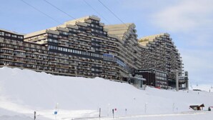Ett hotell med flera våningar, många balkonger och en skidlift som syns i bakgrunden.