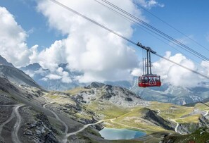 A cable car system in a mountainous area with a clear sky and a lake in the foreground. - 50m from shops, 4th floor, view village, tv, 33m², Les Arcs (Les Arcs)