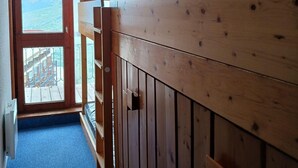 Un intérieur en bois offrant une vue sur un paysage montagneux grâce à une grande fenêtre.