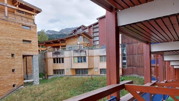 A modern building with a wooden facade, balconies, and a view of mountains. - 50m from resort center, 6th floor, view mountain, tv, 19m², Les Arcs (Les Arcs)