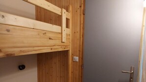 A small, wooden room with a bunk bed and a door. - 50m from resort center, 6th floor, view mountain, tv, 19m², Les Arcs (Les Arcs)