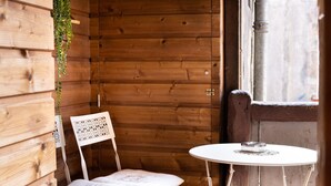 A wooden cabin with a white chair and a small round table. - Cosmo incroyable idéal famille rue Carnot (Annecy)