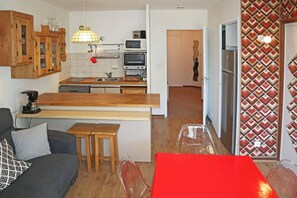 A compact living space with a kitchenette, a dining area, and a sofa. - 15m from ski slopes, 2nd floor, view ski slopes, balcony, 40m², Les Orres (Les Orres)