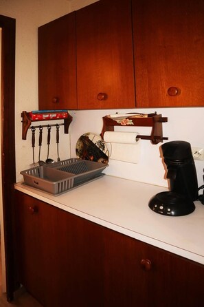 Kitchen area with a coffee maker, basket, and paper towels on the countertop.