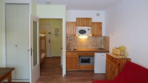 A compact kitchen with wooden cabinets, a microwave, a toaster, and a coffee maker. - Ski-in/ski-out & foot of the slopes, 4th floor, view ski slopes, balcony, tv, 22m², Les Orres (Les Orres)