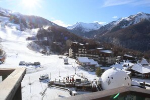A ski resort with a snow-covered slope, buildings, and a dome-shaped structure. - 15m from ski slopes, 8th floor, view ski slopes, balcony, tv, ski locker, 28m², Les Orres (Les Orres)