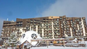 A multi-story hotel with balconies and a large white dome structure in the foreground.