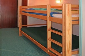 A bunk bed with a green mattress and wooden frame. - 15m from ski slopes, 8th floor, view ski slopes, balcony, tv, ski locker, 28m², Les Orres (Les Orres)