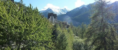 A mountainous landscape with a building nestled among trees.