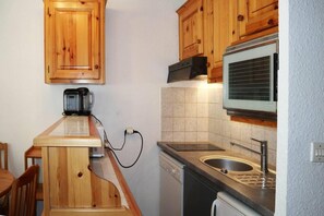 A compact kitchen with wooden cabinets, a coffee maker, a microwave, and a dishwasher. - 15m from ski slopes, 5th floor, view resort, balcony, 28m², Les Orres (Les Orres)