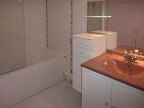 Ein Badezimmer mit Badewanne, Waschbecken und Spiegel.