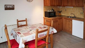 A compact kitchen with wooden cabinets, a microwave, and a sink. - 15m from ski slopes, 5th floor, view valley, balcony, 22m², Les Orres (Les Orres)