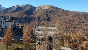 A mountainous landscape with a building featuring a traditional roof in the foreground.