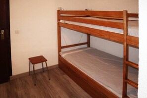 A bunk bed with a small stool beside it, a power outlet on the wall, and a door. - 50m from ski slopes, 4th floor, balcony, 26m², Les Orres (Les Orres)