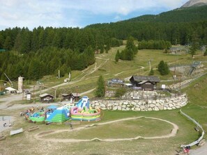 An outdoor amusement park with inflatable slides and a small building. - Ski-in/ski-out & foot of the slopes, 5th floor, balcony, tv, 22m², Les Orres (Les Orres)