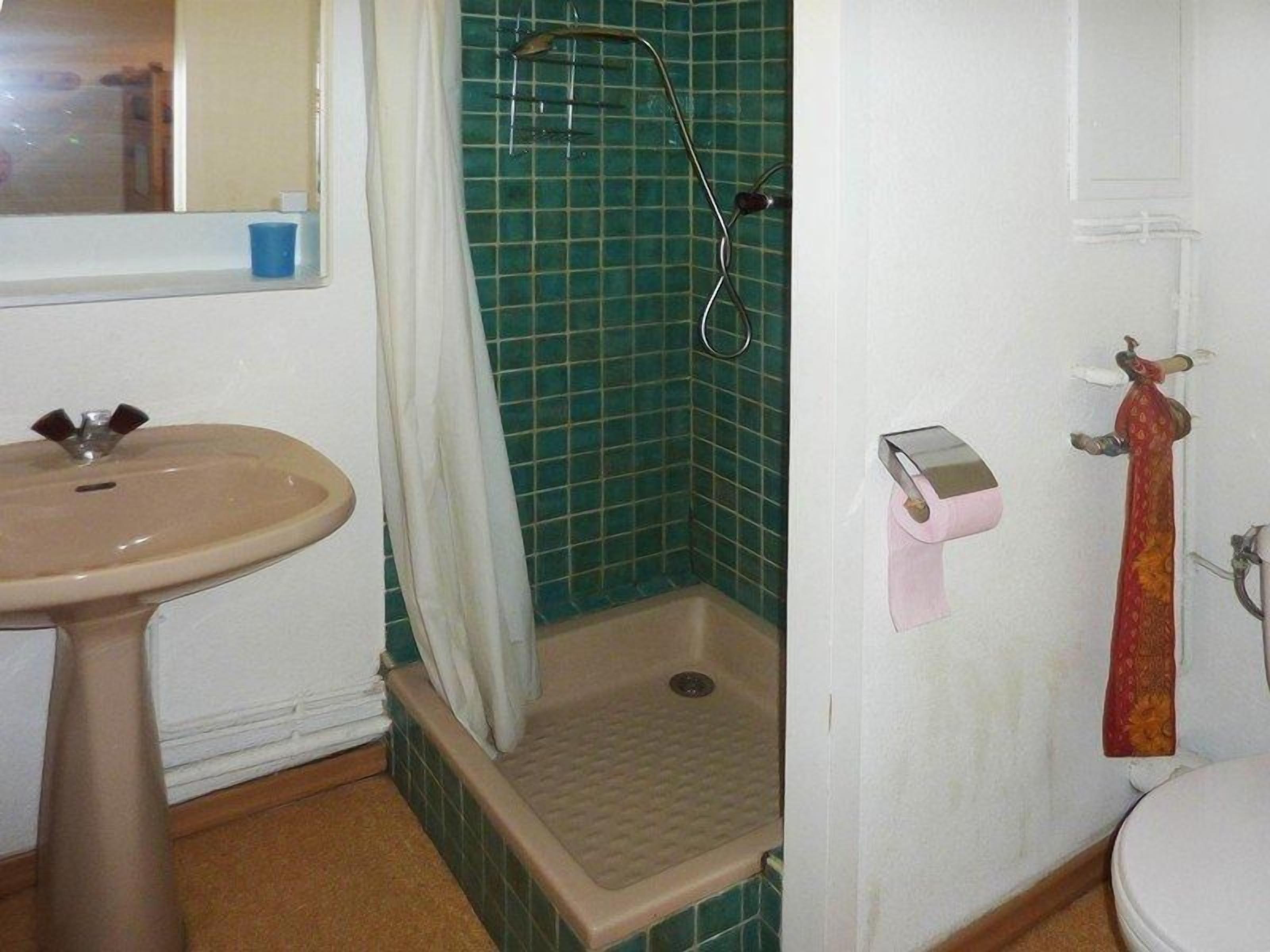 Ein Badezimmer mit Waschbecken, Dusche, Toilette und Handtuchhalter.