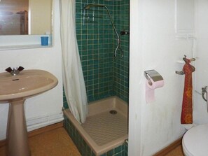 A bathroom with a sink, shower, toilet, and a towel rack.