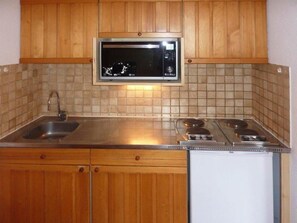 A kitchen with wooden cabinets, a stainless steel countertop, a microwave, and a built-in dishwasher. - Ski-in/ski-out & foot of the slopes, 5th floor, balcony, tv, 30m², Les Orres (Les Orres)