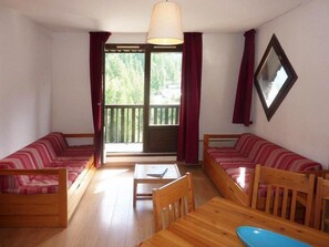 A room with two wooden sofas, a wooden table, and a window with curtains. - Ski-in/ski-out & foot of the slopes, 5th floor, balcony, tv, 30m², Les Orres (Les Orres)