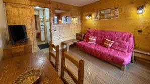 A wooden interior with a sofa, a TV, and a dining table. - 200m from ski slopes, 1st floor, view ski slopes, balcony, tv, ski locker, 26m², Valmorel (Valmorel)