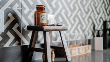 A bottle of Apothic Tobac & Patton on a wooden stool against a patterned wall.