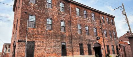 A large brick building with multiple windows and a sign that reads "Tobacco."