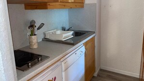 A compact kitchen with a microwave, sink, and dishwasher.