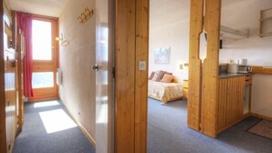 A room with a bed, a wooden cabinet, and a window with curtains.