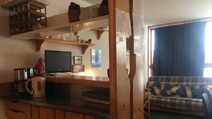 A cozy living area with a wooden kitchenette, a sofa, and a television. - 10m from ski slopes, Ground floor, view valley, balcony, tv, 33m², Les Arcs (Les Arcs)