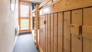 A narrow hallway with wooden paneling on the right, a door at the end, and a window on the left. - 10m from ski slopes, Ground floor, view valley, balcony, tv, 33m², Les Arcs (Les Arcs)