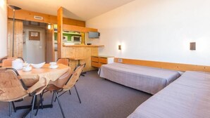 A compact hotel room with a single bed, a small desk, a chair, and a table with a kettle and cups. - 100m from ski slopes, 3rd floor, tv, 33m², Les Arcs (Les Arcs)