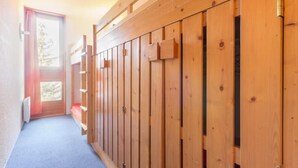 A narrow hallway with wooden paneling and a door leading to a bright room. - 100m from ski slopes, 3rd floor, tv, 33m², Les Arcs (Les Arcs)