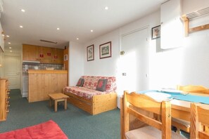 A compact living space with a kitchenette, a sofa, a dining table, and a small wooden stool. - 50m from resort center, 1st floor, balcony, tv, 35m², Les Arcs (Les Arcs)