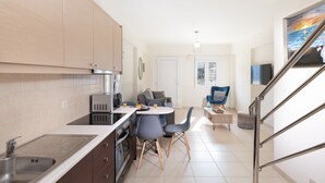 Una cocina moderna con comedor, una escalera y un cuadro en la pared.