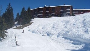 Een skipiste met een gebouw op de achtergrond.
