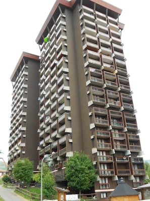 Un edificio residenziale alto con numerosi balconi e un nucleo centrale.