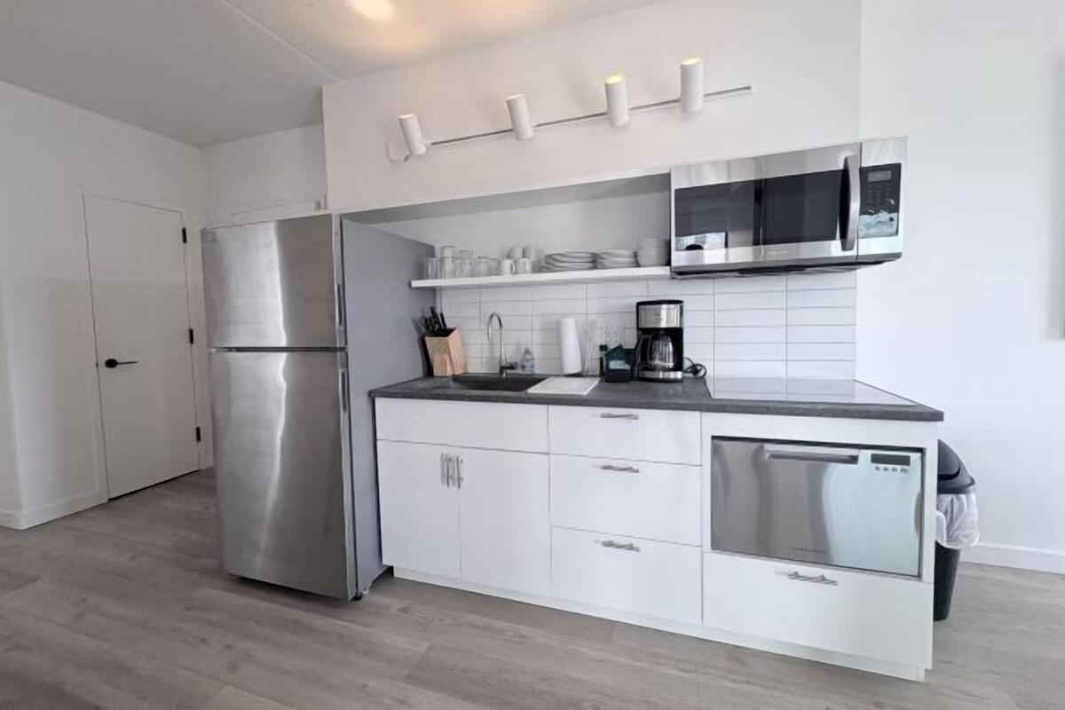 A modern kitchen with a stainless steel refrigerator, a microwave, and a dishwasher.